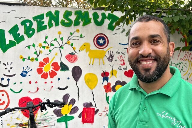 Der Marokkaner Khalid (32) steht in Unna vor einer bunt bemalten Wand an der Intensiv-Pflege-WG „Lebensmut“ beim Pflegedienst Busch