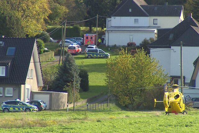 Mehrere Streifenwagen, ein Rettungswagen und ein Rettungshubschrauber stehen vor einem Haus in Dortmund-Sölderholz.
