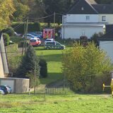 Mehrere Streifenwagen, ein Rettungswagen und ein Rettungshubschrauber stehen vor einem Haus in Dortmund-Sölderholz.