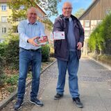 Franz-Josef Klems (74) und Erich Kreß (54) vom Verein „Bürger für Bürger in Unna“ halten die Einkaufsgutscheine der „Aktion Weihnachtsgeld“ in ihren Händen.