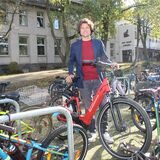 Unnas Klimaschutzmanager Thomas Heer zeigt Fahrradständer an einem Schulgebäude, wo vorher Lehrerparkplätze waren.