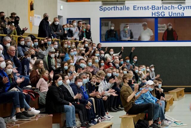 Zuschauer und Fans sitzen auf der Tribüne in der Sporthalle des Ernst-Barlach-Gymnasiums. Viele tragen eine Mundschutzmaske.