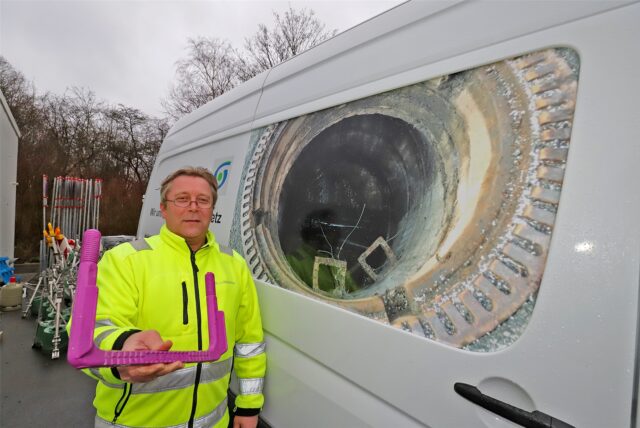 Auf dem Wagen hinter Bernd-Josef Neuhaus ist zu sehen, wie die Trittstufen in den Schächten, die zur Kanalisation in Kamen führen, aktuell noch aussehen. Der Chef der Stadtentwässerung hält die nächste Generation der Steigbügel in der der Hand: Modern und in knalliger Farbe.