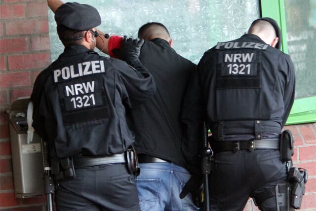 Polizisten kontrollieren einen Mann.