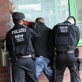 Polizisten kontrollieren einen Mann.