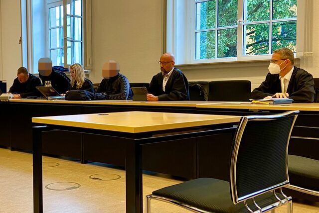 Anwälte und Angeklagte im Gerichtssaal.