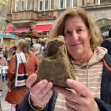Martina Furlan zeigt einen der Steine der mittelalterlichen Dortmunder Stadtmauer, die am Sonntag auf dem Alten Markt herausgegeben worden sind.