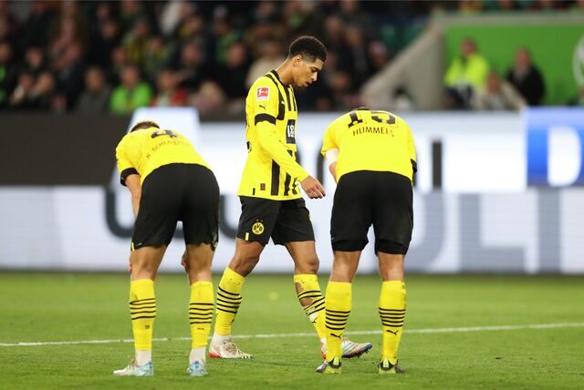 Nico Schlotterbeck, Jude Bellingham und Mats Hummels stehen enttäuscht auf dem Rasen.