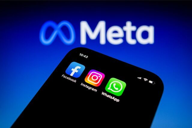 Die Apps von Facebook, Instagram und WhatsApp sind auf einem Smartphone vor dem Logo von Meta Platforms zu sehen.