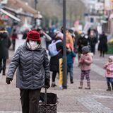 Eine Frau (l) geht mit einer FFP2-Maske geschützt durch die Fußgängerzone.