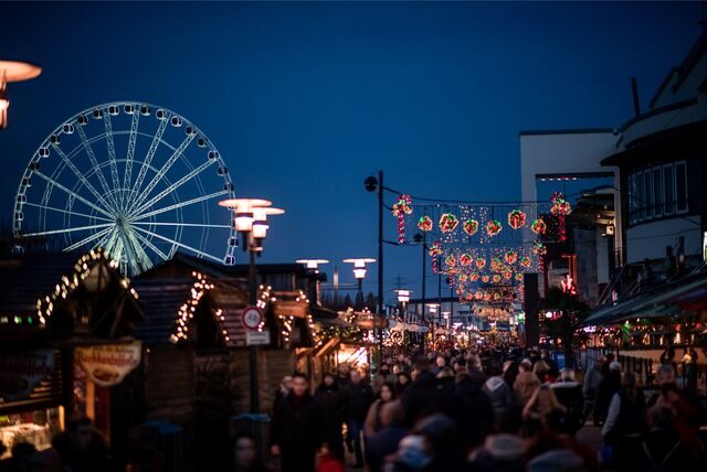 Das Riesenrad steht beleuchtet hinter den Hütten des Weihnachtsmarktes am Centro in Oberhausen.