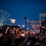 Das Riesenrad steht beleuchtet hinter den Hütten des Weihnachtsmarktes am Centro in Oberhausen.