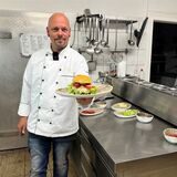 Bob Michaels hält einen Burger in der Hand.