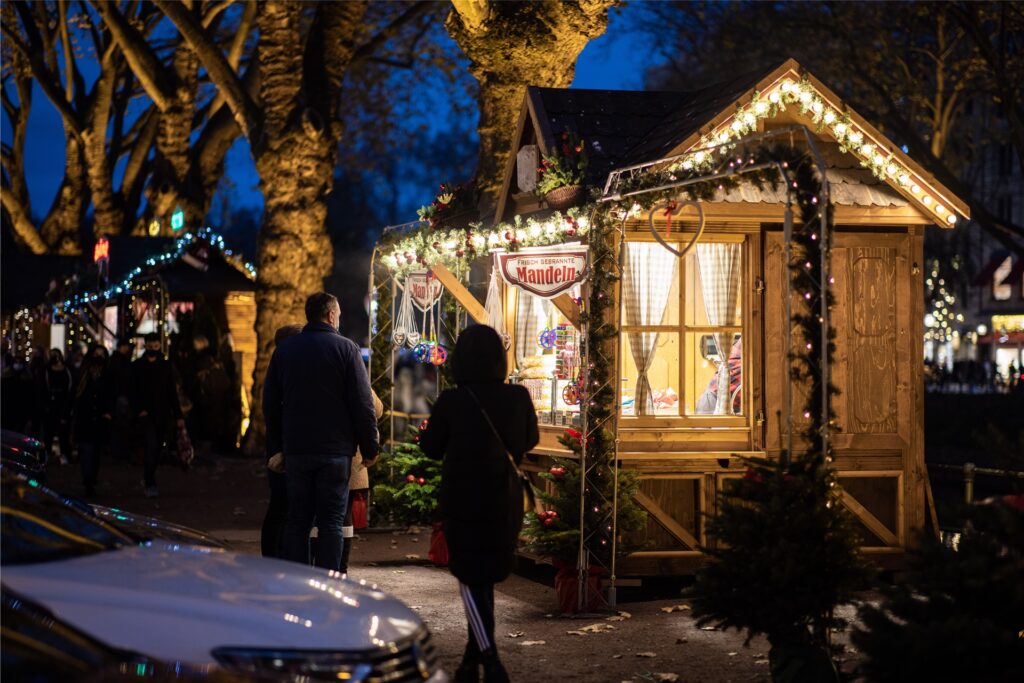 Besucher gehen über den Weihnachtsmarkt an der Besucher gehen über den Weihnachtsmarkt an der
