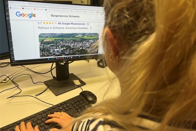 Eine blonde Frau sitzt vor einem Bildschirm und schaut sich die Google-Bewertungen des Bürgerservice der Stadt Schwerte an.