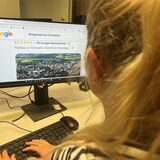 Eine blonde Frau sitzt vor einem Bildschirm und schaut sich die Google-Bewertungen des Bürgerservice der Stadt Schwerte an.