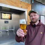 Nico Nahalewicz präsentiert ein frischgezapftes Bier. Seine Gäste können es sich an der Außenwand seiner Gastronomie jetzt selbst zapfen.