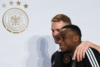 Youssoufa Moukoko sitzt bei einer Pressekonferenz.