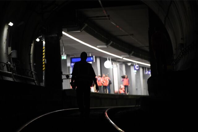 Ein Mann läuft über die Bahngleise in einem dunklen Tunnel.