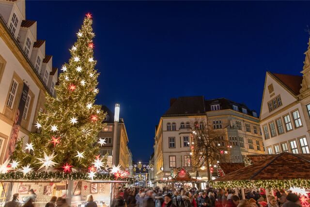 Ein großer, geschmückter Weihnachtsbaum steht auf dem Weihnachtsmarkt in Bielefeld.