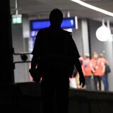 Ein Mann läuft über die Bahngleise in einem dunklen Tunnel.