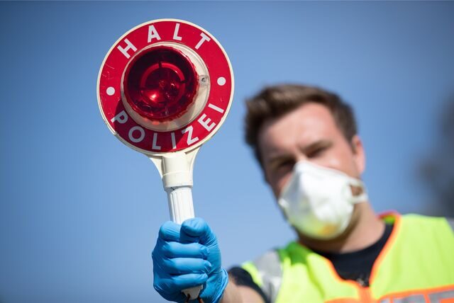 Ein Polizist mit einer Kelle, um Autofahrer anzuhalten.