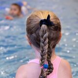 Ein Mädchen nimmt an einem Schwimmkurs teil.