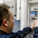Ein Elektriker montiert einen digitalen Stromzähler mit einem Smart-Meter-Gateway zur Datenübertragung.