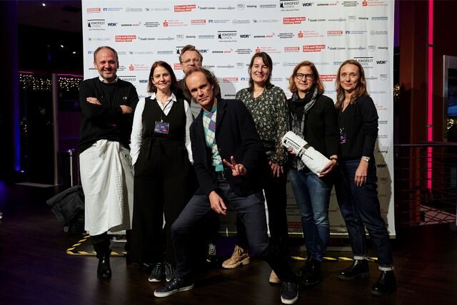 Olaf Schubert (M.) – natürlich im typischen Pullunder – mit dem Team von „Olaf Jagger“ und Kinofest-Leiterin Sonja Hofmann (3.v.r.) in der Cineworld.