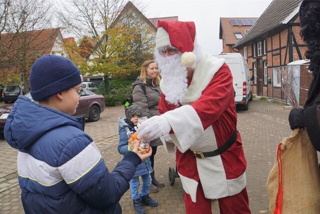 Der Weihnachtsmann gibt einem Kind auf dem Weihnachtsbasar in Herbern Süßigkeiten.
