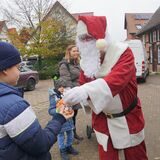 Der Weihnachtsmann gibt einem Kind auf dem Weihnachtsbasar in Herbern Süßigkeiten.