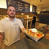 Bei der Frittenküche in der Neue Mühle in Unna kommt in der Regel mehr auf die Pommes als bloß Mayo und Ketchup. Betriebsleiter Jannik Moritz zeigt eine der Kreationen, die sich alle Unnaer ab sofort schmecken lassen können.