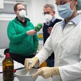 Apotheker Christian Zeidler (m.) zeigt, wie Ibuprofen-Saft hergestellt wird.