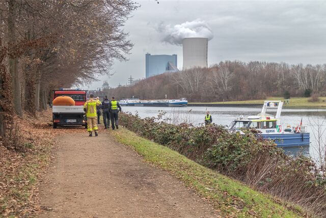 Feuerwehreinsatzkräfte und ein Feuerwehrfahrzeug stehen am Kanal zwischen Waltrop und Datteln.