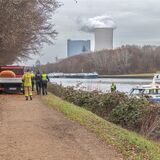 Feuerwehreinsatzkräfte und ein Feuerwehrfahrzeug stehen am Kanal zwischen Waltrop und Datteln.