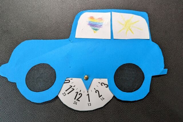 Eine selbst gebastelte Parkscheibe in Form eines blauen Autos.