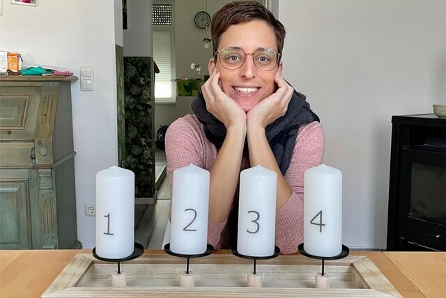 Jeannine Vüllings sitzt vor vier Adventskerzen.