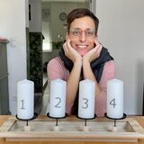 Jeannine Vüllings sitzt vor vier Adventskerzen.