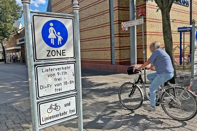 Eine Frau fährt mit dem Fahrrad über die Massener Straße