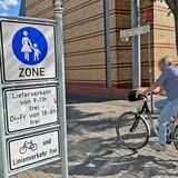 Eine Frau fährt mit dem Fahrrad über die Massener Straße