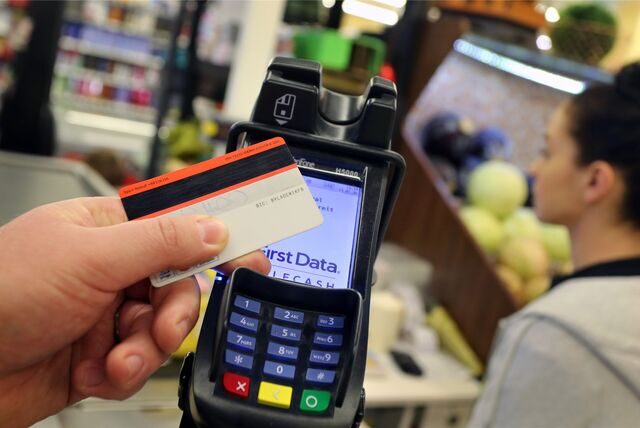 Eine EC-Karte wird an den Bezahl-Terminal an der Kasse eines Supermarktes gehalten.