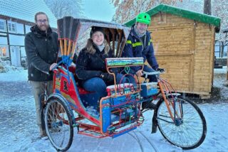Carsten Hellmann (l.), Ronja Kossack und Martin Struck zeigen eine Rikscha in Hemmerde