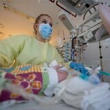 Eine Intensivpflegerin versorgt auf einer Kinder-Intensivstation einen am Respiratorischen Synzytial-Virus (RS-Virus oder RSV) erkrankten Patienten, der beatmet wird.