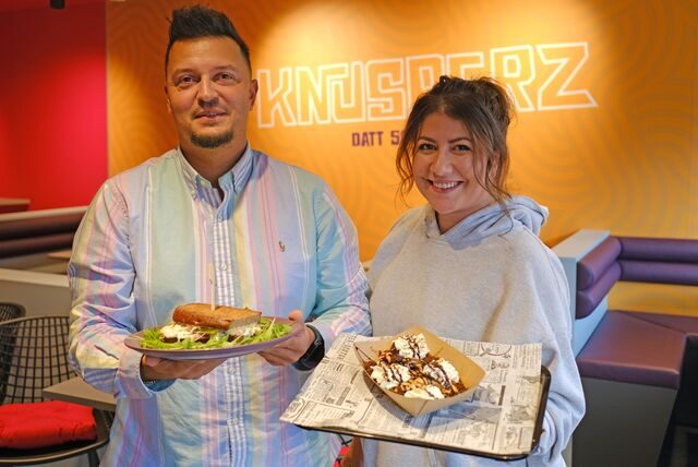 Alexander Scharmacher und Anna-Katrin Badewitz zeigen im Lokal „Knusperz“ in Dortmund zwei Speisen von der Karte.