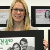 Jana-Larissa Marx (DEW21) und Jennifer Rickers (Stadtmarketing) halten ein paar der Plakate, mit denen die Stadt Dortmund für das Energiesparen werben will.