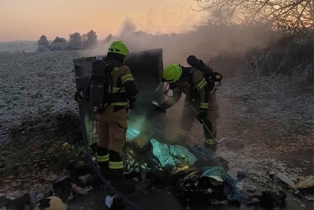 Der Inhalt des Altkleidercontainers wurde zerstört: Feuerwehrleute an der Einsatzstelle in Werve.
