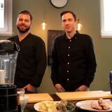 Sternekoch Philip Schneider und Moderator Bastian Pietsch in der Show-Küche. Im Vordergrund liegen einige Zutaten auf dem Tisch.
