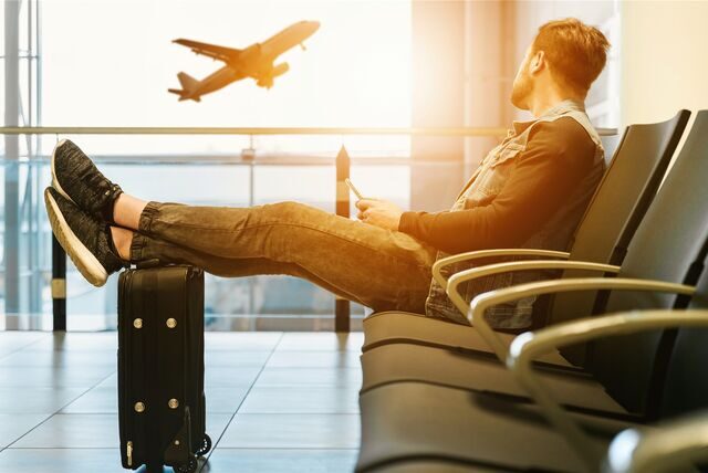 Ein Mann sitzt im Wartebereich an einem Flughafen
