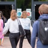 Schüler gehen auf den Eingang der Schule zu.