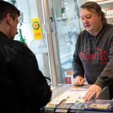 Ein Mann nimmt in einem Lotto-Laden einen Tippschein entgegen.